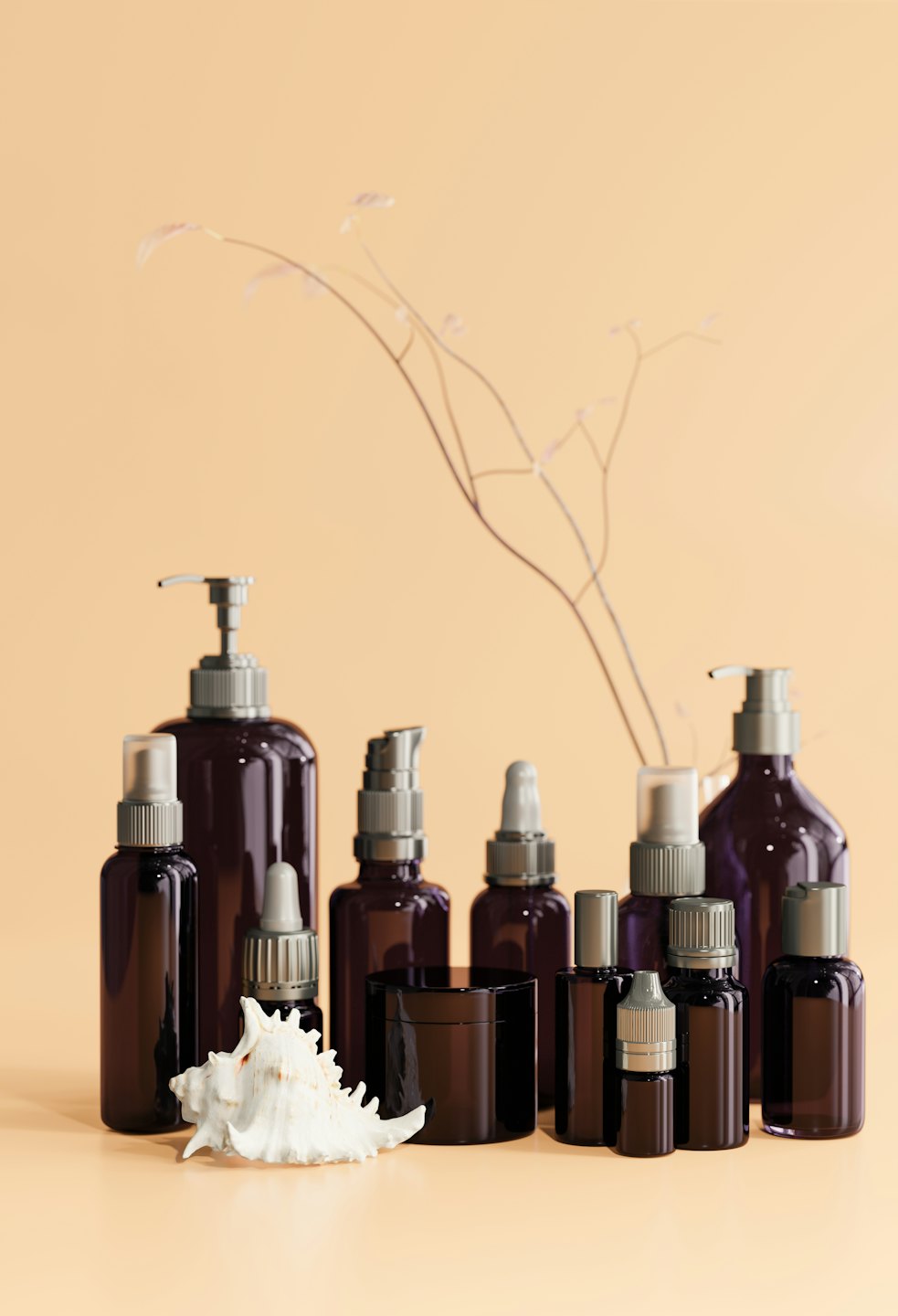Cosmetic bottles arranged with a seashell and dried branches.