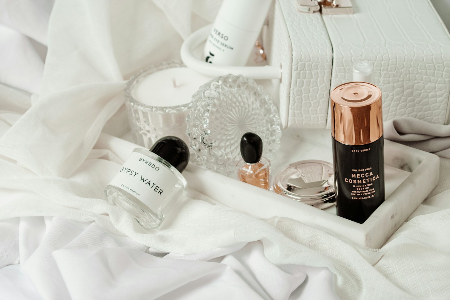 Luxury beauty products arranged on a marble tray.